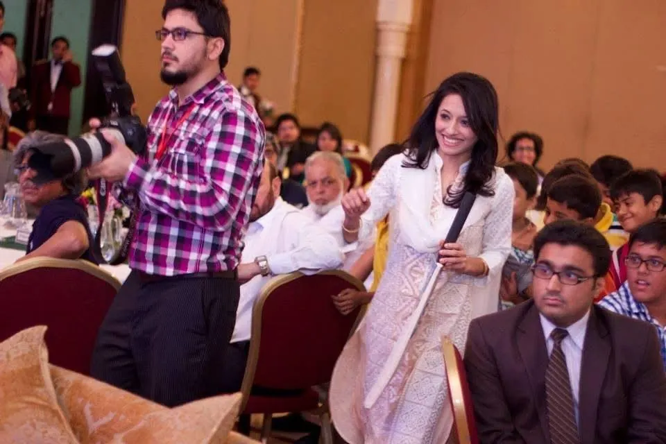 Sarah Mashhood out among a seated audience with a microphone