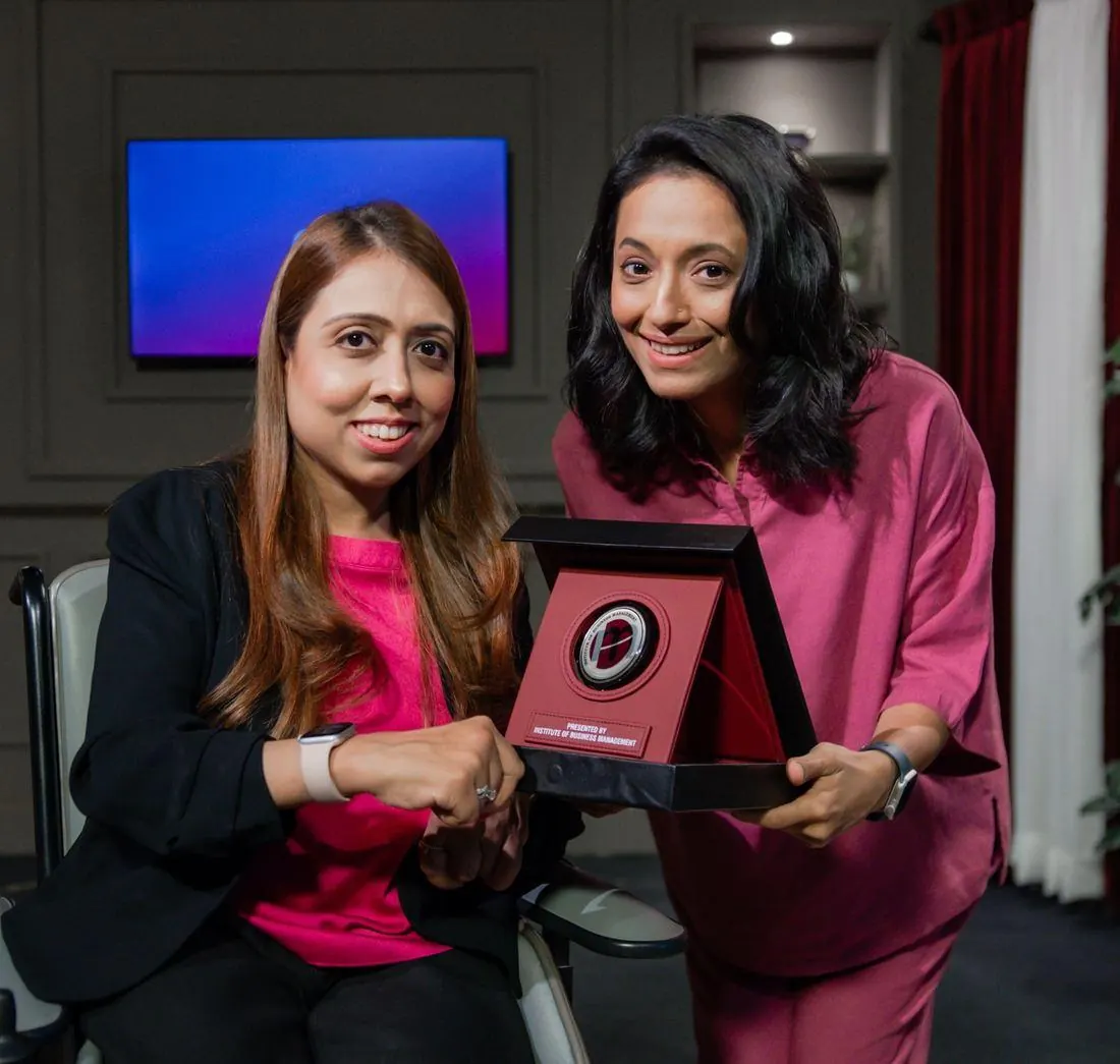 Sarah Mashhood presenting the IoBM shield to a guest on set